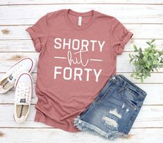 a t - shirt that says shorty but forty on it next to denim shorts