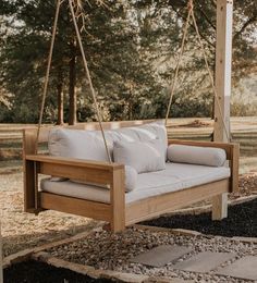 a white couch sitting on top of a wooden swing