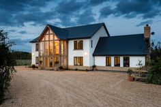 a large white house sitting on top of a gravel road