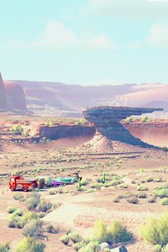 two trucks are parked in the desert near some rocks and grass with mountains in the background