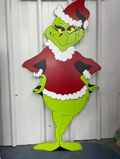 the grinch is standing in front of a door