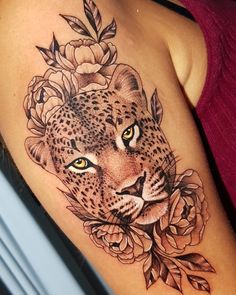 a woman's arm with a leopard and flowers tattoo on the left side of her body