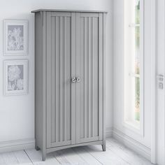 a gray cabinet in a white room with pictures on the wall