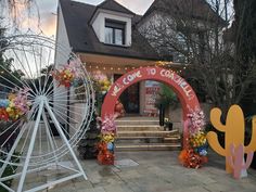 an entrance to a house decorated with fake flowers and cactus decorations in front of it