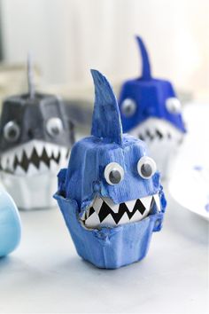 some blue and white cupcakes with fake teeth on them are sitting on a table