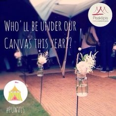 there are flowers in vases on the ground with an advertisement above them that says who'll be under our canvas this year?