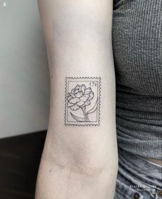 a woman's arm with a small flower tattoo on the left side of her arm