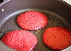 three hamburger patties cooking in a frying pan