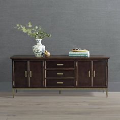 a sideboard with flowers and books on it