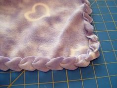 a close up of a cloth on a cutting board with a ruler and scissors in the background