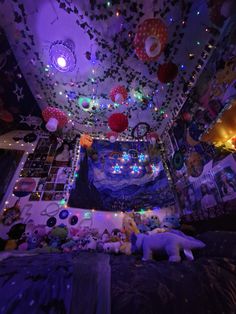 a bed room with a bunch of stuffed animals and lights on the ceiling above it