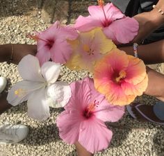 three women are holding flowers in their hands and one is wearing flip flops on the ground