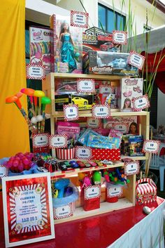 there are many items on the table for sale at this carnival event, including popcorn buckets and candy boxes