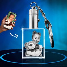 a person holding a cell phone and a keychain with a photo on it