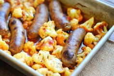 some sausages and cauliflower are in a dish