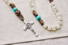 Grab your spiritual weapon and pray with us! This paracord rosary is designed for anybody who wants to walk out on the battlefield prepared, guaranteed to never break or fail you in battle! - Features the Divine Hope design with a brown rope, teal Our Father beads, and cream/transparent Hail Mary beads with a standard sized 2" St. Benedict Crucifix. - The Devotional Medal on this design is the Miraculous Medal - Overall length is approximately 19 inches for the full rosary, and 9 inches for the Handmade Adjustable Spiritual Rosary, Handmade Adjustable Rosary For Meditation, Adjustable Handmade Rosary For Meditation, Adjustable Hand-strung Healing Rosary, Hand-strung Rosary Bracelet With Round Beads For Meditation, Traditional Adjustable Hand-strung Rosary Bracelet, Paracord Rosary, Military Rosary, Meditation Cross-shaped Beaded Rosary