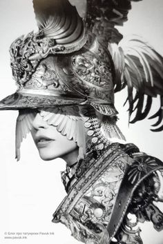 a woman wearing a large hat with feathers on it's head and an elaborate helmet