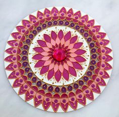 a pink and white plate with an intricate design on it