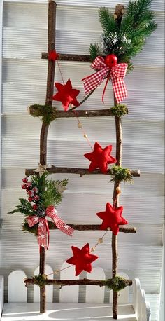 a christmas tree made out of branches with red and white stars hanging from the top