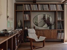 a record player is sitting in front of a bookshelf filled with vinyl records