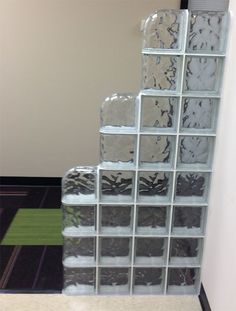 several glass blocks stacked on top of each other in front of a wall mounted mirror