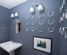 a white sink sitting under a bathroom mirror next to a wall mounted faucet