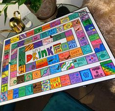 a board game is sitting on a table with a teddy bear and potted plant in the background