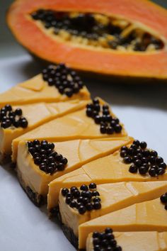 slices of cheesecake with blackberries and papaya