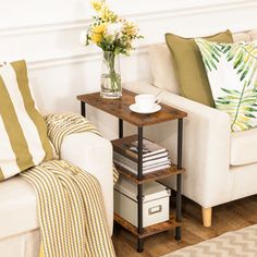 a living room filled with furniture and flowers on top of a wooden table next to a white couch