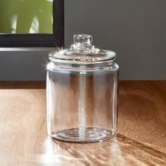 a glass jar sitting on top of a wooden table