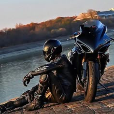 a person sitting on the ground next to a motorcycle