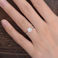 a woman's hand with a diamond ring on it