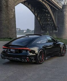 a black sports car parked in front of a bridge