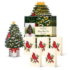 a christmas tree and greeting cards are shown in front of a box with lights on it