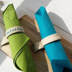 two green and blue umbrellas sitting on top of a wooden floor next to each other