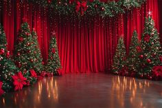 a stage with red curtains and christmas trees