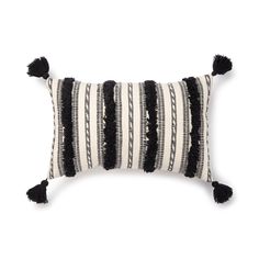 a black and white striped pillow with tassels