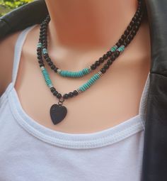 Natural gemstone blue turquoise & matte black onyx beaded layered necklace, with black enamel heart pendant adjustable back lobster claw clasp + extension chain. Set of 2 pieces. Material: -Natural gemstone - blue turquoise (6mm x 2 mm), matte black onyx (6mm). Pendant: zinc alloy enamel heart pendant (23mm x 23mm"  (lead & nickel free) - black stainless steel back lobster claw clasp & extension chain) - metal - antique silver spacers Necklace length: Layer 1 - 17.25" long ( includes 2" extension chain) Layer 2 - 18" long (includes 2" extension chain) ------------- SHIPPING ◊ Get your orders FAST! Our processing time is only 1-2 business days for most orders.  ------------------- JEWELRY PACKAGING ◊ This listing comes packaged in our high quality cardboard jewelry box with silver glitter c Black Adjustable Double Strand Jewelry, Adjustable Black Jewelry With Heart Charm, Handmade Adjustable Black Turquoise Necklace, Adjustable Black Necklace With Heart Charm, Black Necklace With Adjustable Heart Charm, Black Multi-strand Layering Jewelry, Black Adjustable Heart Pendant Necklace, Black Bohemian Turquoise Necklace As A Gift, Black Bohemian Turquoise Necklace Gift