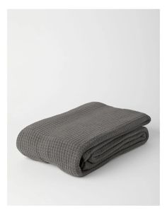 a gray blanket folded on top of a white table