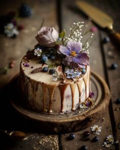 a cake decorated with flowers and icing on a wooden table