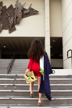 a woman walking up some steps with a sign on her hand and a coat over her shoulder