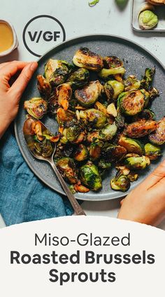 a plate full of roasted brussel sprouts with two hands on the side