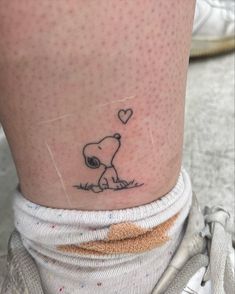 a small tattoo on the leg of a person with a heart shaped balloon above it