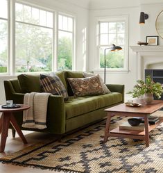 a living room filled with furniture and a fire place in front of a large window