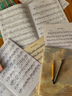 several sheets of sheet music and a pen on a table