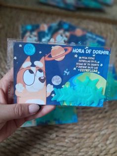 a person holding up a card with an image of cartoon characters on it and space in the background