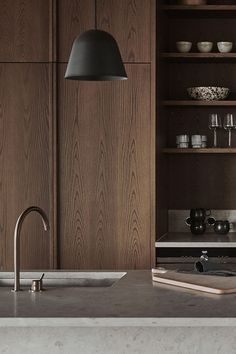 a kitchen with wooden cabinets and stainless steel appliances, including a sink that has a faucet on it