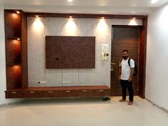 a man standing in front of a wall mounted flat screen tv next to a doorway