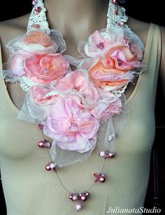 a mannequin with pink flowers and pearls on it's neckpieces