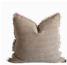 a beige pillow with fray edges and fringes on the bottom, against a white background